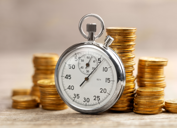 Stacks of coins behind a stopwatch signifying how quickly a borrower can receive a 24-hour loan or an instant cash loan even if they have a bad credit score